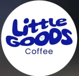 Logo berbentuk lingkaran putih dengan tulisan "Little Goods" berwarna biru tua dalam font bubbly yang tebal. Terdapat ikon wajah tersenyum kecil di dalam huruf 'O' dan kata "Coffee" dengan font sans-serif bersih di bagian bawah.