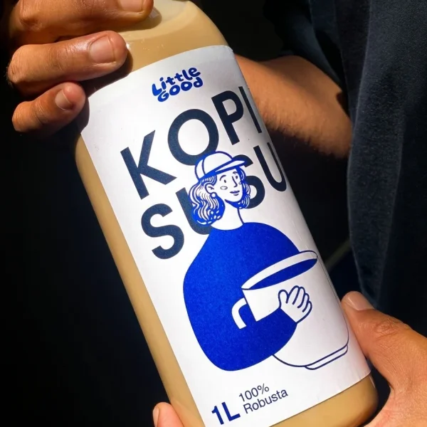 Kopi Literan "Little Good" – Vibes Estetik ☕️ Botol 1 liter kopi susu "Little Good" dipegang dua tangan dengan lighting yang aesthetic. Labelnya putih minimalis dengan ilustrasi karakter biru pake topi dan tulisan "KOPI SUSU".